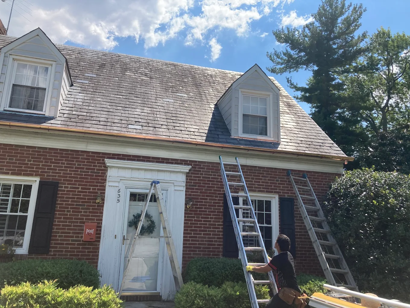 Cedar shake roof with copper drip edge on a brick colonial